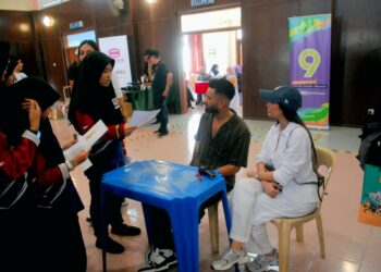 REDZA Rosli ditemani Bella Hanna berbual dengan seorang pelajar pada program CSR School Activation di SMK Ayer Keroh, Melaka. - UTUSAN/AMRAN MULUP