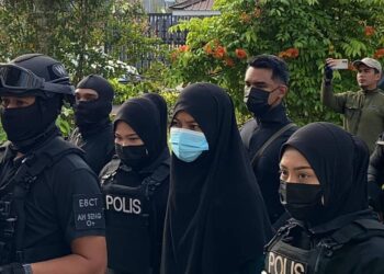 SUHAINI dikawal ketat anggota polis bersenjata ketika dibawa ke Mahkamah Sesyen Kota Tinggi atas pertuduhan memiliki bahan berkaitan pengganas.