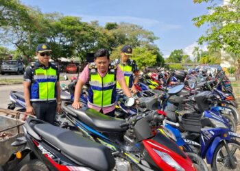 MOHD. Zamri Samion (tengah) memeriksa sebahagian daripada kenderaan yang ditahan dalam Ops Pewa di Kemaman, hari ini. - UTUSAN/NIK NUR IZZATUL HAZWANI NIK ADNAN