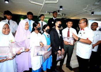 SUHAIZAN Kaiat beramah mesra dengan pelajar yang menghadiri Majlis Pelancaran Anak Angkat Berjaya Akademik di SMK Bandar Uda Utama, Johor Bahru.