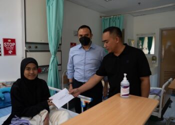 PUTERI Nur Amalin (kiri) menerima sumbangan bagi kos perubatan daripada wakil Perdana Menteri.