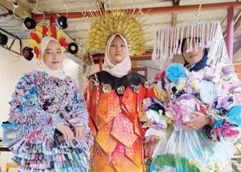 AMNI Amni Maisarah M. Tuah (dari kiri), Qamarina Husna Azizi dan Siti Nur Fatihah Rahman menggayakan rekaan pakaian mereka yang dihasilkan menggunakan barangan kitar semula di Negeri Sembilan, baru-baru ini. – UTUSAN/NOR AINNA HAMZAH