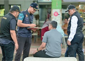 PEGAWAI Kesihatan mengeluarkan notis kesalahan kepada perokok di kawasan larangan merokok dalam Operasi Cakna Undang-Undang Kesihatan Awam di Medan Selera Pantai Batu Burok, Kuala Terengganu, semalam. – UTUSAN/PUQTRA HAIRRY