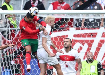 CRISTIANO Ronaldo melompat tinggi untuk menanduk bola walaupun dicabar pertahanan Turkiye pada aksi kedua Kumpulan F melibatkan kedua-dua pasukan di Euro 2024, sebentar tadi.-AFP