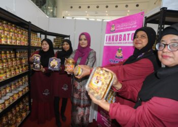 ROZITA Mohd. Sanusi (tengah) bersama usahawan asnaf menunjukkan kuih dan kek keluaran Usahawan Sri Enterprise.