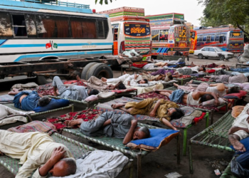 PEMANDU bas berehat dan tidur akibat cuaca panas di stesen bas, Lahore, Pakistan. -AFP