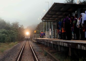 PELAJAR Sekolah Menengah Kebangsaan Dabong menunggu ketibaan kereta api 
di Hentian Kuala Gris, Kuala Krai, Kelantan.  
– UTUSAN/KAMARUL BISMI KAMARUZAMAN