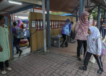 BEBERAPA guru mengawasi keselamatan  pelajar yang tiba ke sekolah bagi sesi pembelajaran di Sekolah Kebangsaan Yaacob Latif di ibu negara baru-baru ini. – UTUSAN/FARIZ RUSADIO.