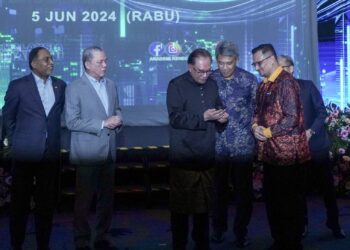 Datuk Seri Anwar Ibrahim melakukan gimik menekan telefon bimbit ketika Majlis Peluncuran Modul Latihan Kenegaraan Malaysia di Dewan Seri Siantan, Perbadanan Putrajaya di sini, semalam. Turut sama, Ketua Pengarah Akademi Kenegaraan, Mohd Haswandi Ahmad.– Utusan/FAISOL MUSTAFA