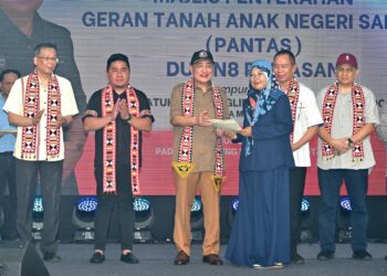 HAJIJI Noor (tiga kiri) menyerahkan geran PANTAS kepada salah seorang penerima di Kota Belud, hari ini