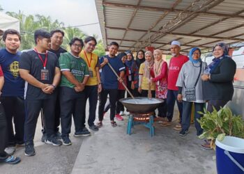 PENDUDUK dan mahasiswa UTM bersama-sama mengacau dodol sempena Program Siswa Noghori Turun Padang di Masjid Kariah Kampung Terusan, Kuala Pilah hari ini.-UTUSAN/NOR AINNA HAMZAH.