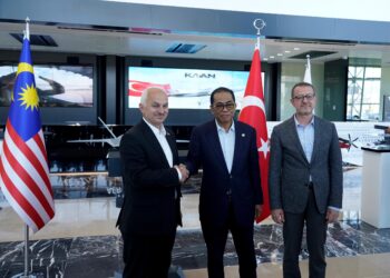 Mohamed Khaled (tengah) berjabat tangan dengan Presiden dan Ketua Pegawai Eksekutif Turkish Aerospace Industries, Prof. Dr. Temel Kotil (kiri) pada lawatan industri ke syarikat pertahanan itu hari ini. - Foto oleh  FAUZI BAHARUDIN