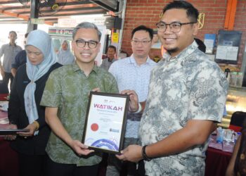 FAHMI  Fadzil menyampaikan watikah Komuniti Madani Kempas kepada wakil Dun Kempas pada Program Sembang Santai YB Fahmi Fadzil Bersama Komuniti Madani Parlimen Pulai di Bistro Papa Jenggo, Desa Rahmat Johor Bahru di sini. – UTUSAN/RAJA JAAFAR ALI