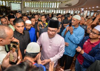 ANWAR Ibrahim beramah mesra bersama jemaah ketika hadir menunaikan solat jumaat di Masjid Tun Abdul Aziz, Petaling Jaya di sini hari ini. UTUSAN/SYAKIR RADIN