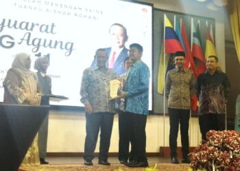 AMINUDDIN Harun menyampaikan BKAP Negeri Sembilan kepada penerima pada Majlis Perasmian Mesyuarat Agung PIBG Sekolah Menengah Sains Tuanku Aishah Rohani di Seremban hari ini.-UTUSAN/NUR SHARIEZA ISMAIL.