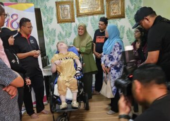 Mohamad Zahri Samingon (empat, kiri) ketika menyerahkan sumbangan kepada pesakit albino di Pangsapuri Petaling Perdana, Petaling Jaya, hari ini. - UTUSAN/FATIN NORIZATI MAT ISA