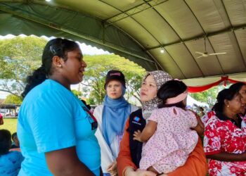 FADHLINA Sidek (mendukung bayi) menyantuni penduduk setempat di Simpang Ampat, Nibong Tebal, petang tadi
