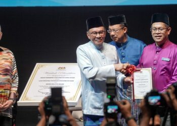 ANWAR Ibrahim menyampaikan watikah pelantikan kepada Mohd Afendi bin Ya @ Zakaria sebagai simbolik mewakili seluruh ahli AKRAB bertauliah pada Himpunan Aspirasi Madani AKRAB di PICC Putrajaya. - UTUSAN/FAISOL MUSTAFA