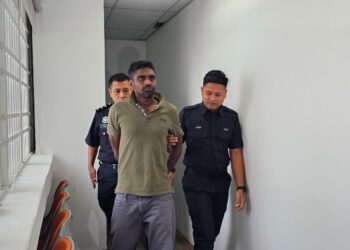 S. SUGAN (tengah) dihadapkan ke Mahkamah Majistret Ipoh hari ini atas tuduhan membunuh ibu kandung dua minggu lalu. - UTUSAN