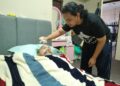 MUHAMMAD Afif Mohd. Ezani menjaga ayahnya, Mohd. Ezani Abas yang terlantar setelah menghidap kanser otak di kediaman mereka di Kampung Tiong, Kuala Terengganu. - UTUSAN/KAMALIZA KAMARUDDIN