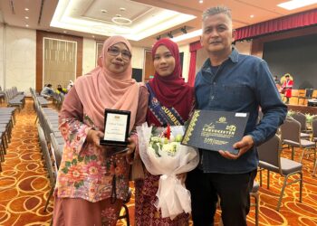 NURIN Alya Halid, 26, yang juga pemilik Rinleed Batik dinobatkan sebagai penerima Anugerah Sumber Inspirasi bersama kedua ibu bapanya, Noorsaadah Mashudi dan Halid Ahmad pada Majlis Konvokesyen Persijilan Kemahiran Malaysia Murid Berkeperluan Khas Tahun 2024 di Putrajaya. - UTUSAN/KAMARIAH KHALIDI