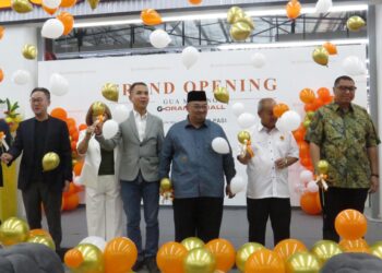 RAYMOND Ng (tiga dari kiri) dan Mohamed Fadzli Hassan (tiga dari kanan) memecahkan belon sebagai gimik perasmian Pasar Raya G-Orange di Bandar Utama, Gua Musang, Kelantan semalam. – UTUSAN/AIMUNI TUAN LAH