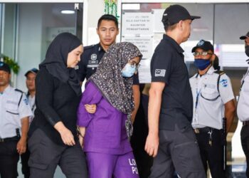 Ibu Zayn Rayyan  Abdul Matiin diiringi polis semasa beredar dari Kompleks Mahkamah Petaling Jaya hari ini. - UTUSAN/SHIDDIEQIIN ZON
