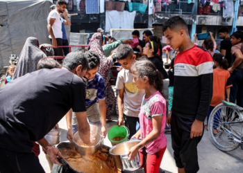 KANAK-KANAK beratur menunggu bantuan makanan di dapur Sekolah Abu Zeitun di kem pelarian Jabalia, utara Gaza. -AFP