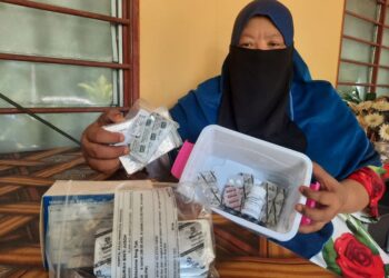 NIK Suria Jusoh menunjukkan pelbagai jenis ubat yang perlu diambilnya bagi mengurangkan kesakitan akibat kanser limfoma di Kampung Padang Limau, Karangan, Kulim, Kedah. – UTUSAN/AZAHAR HASHIM