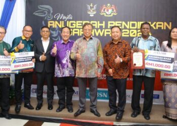 Abang Johari (tengah), Azhar (empat kanan) dan Wan Munadi (empat kiri) bergambar dengan para penerima Anugerah Pendidikan Sarawak 2024, semalam.