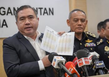 ANTHONY Loke menunjukkan kadar fi LKM kenderaan EV pada sidang akhbar di Putrajaya. - UTUSAN/FAISOL MUSTAFA