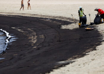 PEKERJA membersihkan kesan tumpahan minyak di Pantai Tanjong, Sentosa.- AGENSI
