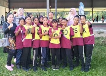 NORIAH a/p Pandak (depan, kiri) bersama pasukan bola jaring bawah 12 tahun murid Orang Asli di Sekolah Kebangsaan Sungai Kiol, Jerantut baru-baru ini.