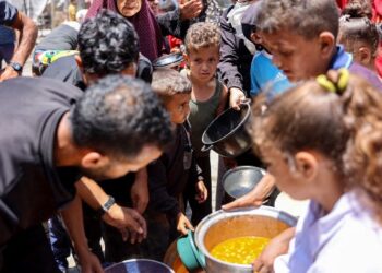KANAK-KANAK beratur untuk menerima makanan di sekolah dekat Kem Jabalia, baru-baru ini. - AFP