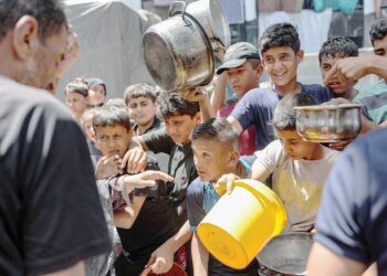 KANAK-KANAK Palestin beratur untuk mendapatkan bantuan makanan di Sekolah Abu Zeitun di Kem Jabalia di utara Gaza, baru-baru ini. Mereka kini berdepan risiko maut akibat kekurangan makanan berkhasiat. – AFP