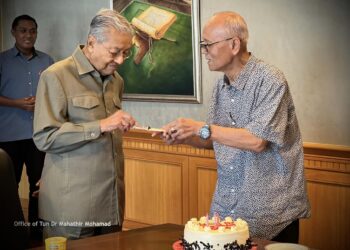 MAHATHIR Mohamad bersama Ismail Manaf (kanan) bermesra ketika memotong kek. - Facebook/Dr. Mahathir bin Mohamad.