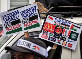 PENUNJUK perasaan membawa sepanduk menyeru boikot produk dan syarikat pro-Israel semasa protes solidariti terhadap rakyat Palestin di Yogyakarta, pada 11 November 2023.- AFP