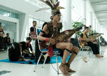 PEMUZIK sape dari etnik Dayak ketika membuat persembahan di Lapangan Terbang Antarabangsa Sultan Aji Muhammad Sulaiman Sepinggan di Balikpapan, Kalimantan Timur. -AFP