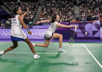 PEARLY Tan (kanan) melakukan pukulan di hadapan M. Thinaah dalam perlawanan peringkat kumpulan badminton beregu wanita Sukan Olimpik Paris 2024 di Arena Porte de la Chapelle, hari ini. - AFP