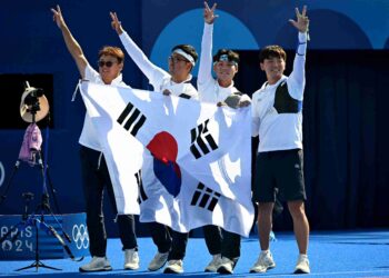 (DARI kanan) Kim Je-deok, Lee Wooseok dan Kim Woo-jin dari Korea Selatan, meraikan kejayaan selepas memenangi perlawanan akhir berpasukan lelaki memanah semasa Sukan Olimpik Paris 2024 di Esplanade des Invalides, hari ini. - AFP