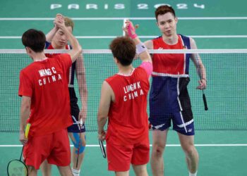 Wang Chang dan Liang Wei Keng (baju merah) dari China berjabat tangan dengan Aaron Chia-Soh Wooi Yik selepas perlawanan peringkat kumpulan beregu lelaki badminton semasa Sukan Olimpik Paris 2024 di Porte de la Chapelle Arena, hari ini. - AFP