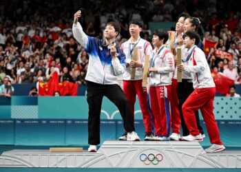 LIM Jong Hoon (kiri) mengambil gambar swafoto ketika meraikan di atas podium bersama pemenang pingat emas dari China, Wang Chuqin-Sun Yingsha dan pemenang pingat perak dari Korea Utara Ri Jong Sik-Kim Kum Yong serta rakan sepasukannya Shin Yubin aksi final pingpong beregu campuran pada Sukan Olimpik Paris 2024 di Arena South Paris, semalam. - AFP