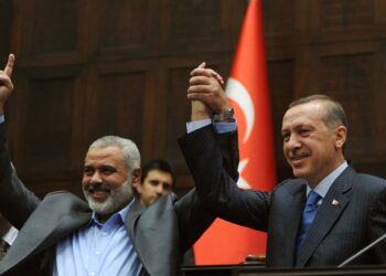 ISMAIL Haniyeh dan Recep Tayyip Erdogan menunjukkan simbol kesatuan semasa pertemuan di bangunan Parlimen di Ankara, 3 Januari 2012.- AFP