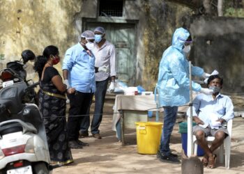 PEKERJA kesihatan melakukan ujian pengesanan Covid-19 menggunakan sampel air liur atau calitan hidung dan tekak di hospital kerajaan di Hyderabad, India.- AFP