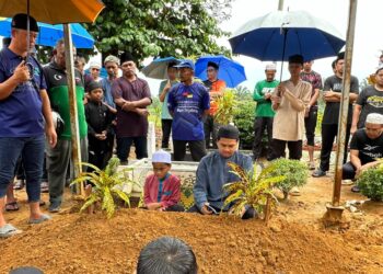 ABD. HALID membaca talkin tanda penghormatan terakhir untuk anaknya, Hafiz Fauzan yang disemadikan di Tanah Perkuburan Islam Batu 7, Tongkang Pechah, Batu Pahat, hari ini.