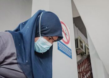 TERTUDUH dihadapkan ke Mahkamah Majistret, Ayer Keroh, Melaka bagi pertuduhan menyamar sebagai staf BNM dan menipu ibu angkatnya. - UTUSAN/SYAFEEQ AHMAD