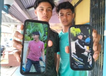 FARIHAN Haikal Mohd Rasdi (kiri) menunjukkan gambar Muhammad Shahrul Huzaimi manakala rakan sebelahnya menunjukkan gambar Muhammad Alif Haikal semasa ditemui di Unit Forensik Hospital Pasir Mas, Kelantan semalam. – UTUSAN/ROHANA ISMAIL
