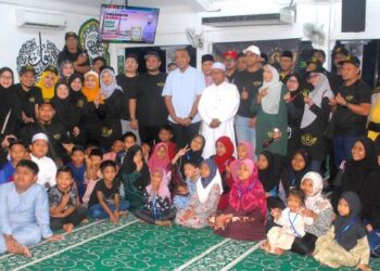 MOHD. Noor Helmy Abdul Halem (berdiri, tengah) bergambar bersama anak yatim dan golongan asnaf di Masjid Fat'hur Rahman, Pengkalan Rama, Melaka, hari ini. - UTUSAN/AMRAN MULUP
