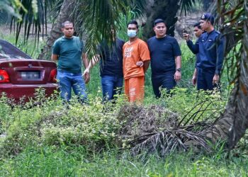 Suspek yang juga anggota polis dibawa ke lokasi penemuan mayat Nur Farah Kartini di ladang kelapa sawit Kampung Sri Kledang, Hulu Selangor semalam. – UTUSAN/M. FIRDAUS M. JOHARI