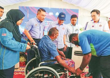 ONN Hafiz Ghazi (berdiri, tengah) menyaksikan penyampaian bantuan kerusi roda oleh Ketua Sistem Insurans Pekerjaan Perkeso, Azirruan Arifin kepada seorang  penerima dalam program Gegar Gerak Kerjaya Mega Myfuturejobs Johor 2024 di Stadium Tertutup MBJB Arena, Larkin, Johor Bahru, semalam.